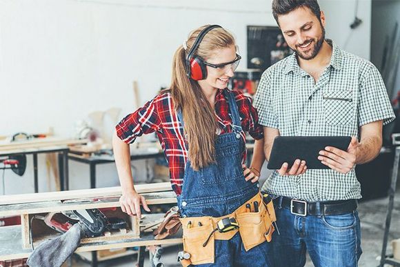 Zwei Personen betrachten Tablet in Werkstatt